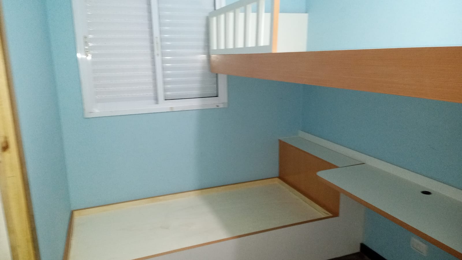 Quarto infantil com cama sob medida com escorregador, prateleira e escrivaninha em MDF branco e amadeirado.